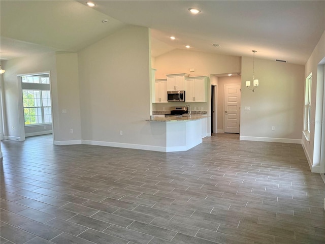10023 Greetings St, Port Charlotte, FL 33981 - unfurnished living room with lofted ceiling, a chandelier, and recessed lighting