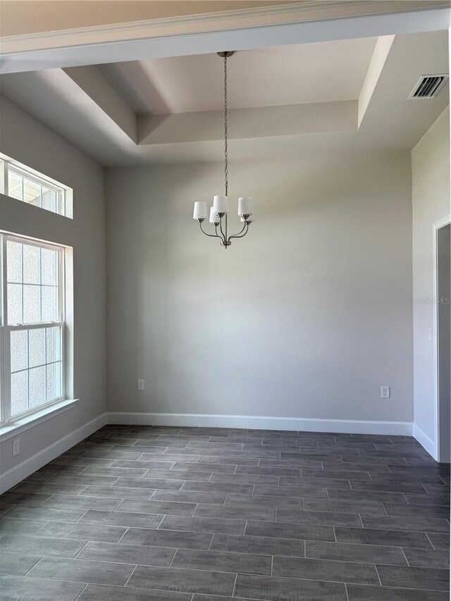 10023 Greetings St, Port Charlotte, FL 33981 - empty room with a tray ceiling, wood tiled floors, a chandelier, and plenty of natural light