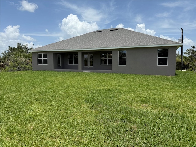 10023 Greetings St, Port Charlotte, FL 33981 - rear view of property with stucco siding, a yard, and roof with shingles