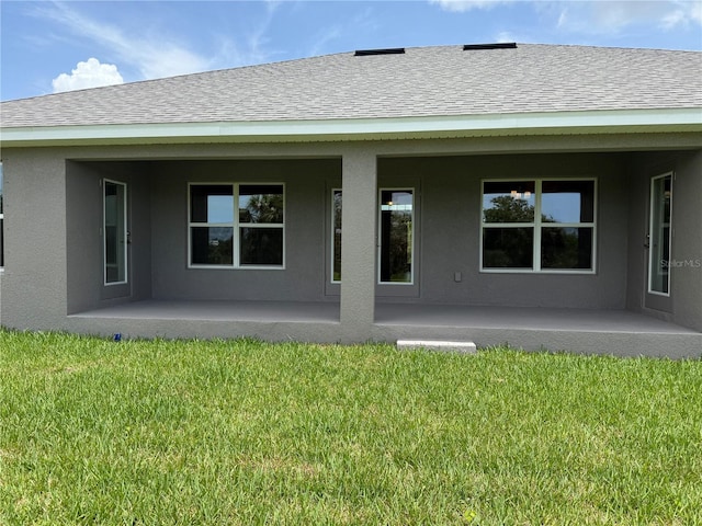10023 Greetings St, Port Charlotte, FL 33981 - back of property with a patio, a lawn, stucco siding, and roof with shingles