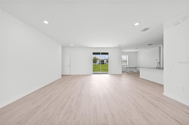 2138 Blaser St, Punta Gorda, FL 33980 - unfurnished living room with light wood-style flooring and recessed lighting