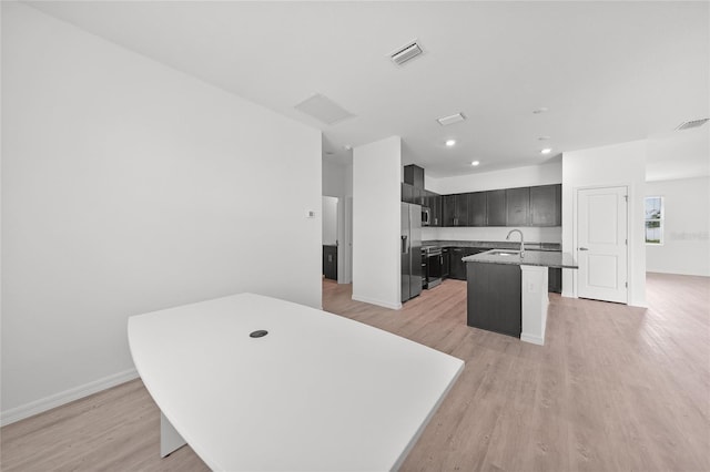 2138 Blaser St, Punta Gorda, FL 33980 - kitchen with an island with sink, light wood finished floors, recessed lighting, stainless steel appliances, and a kitchen breakfast bar