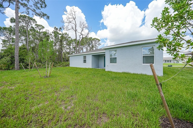 2138 Blaser St, Punta Gorda, FL 33980 - back of property featuring stucco siding and a yard