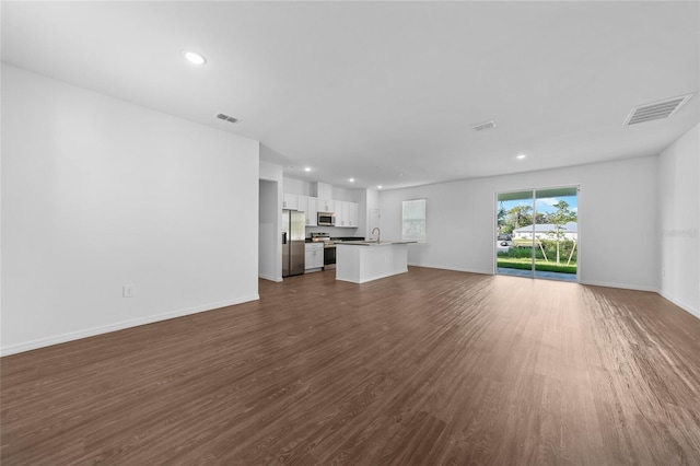 7345 Ellis Ln, Port Charlotte, FL 33981 - unfurnished living room with recessed lighting and dark wood-style flooring