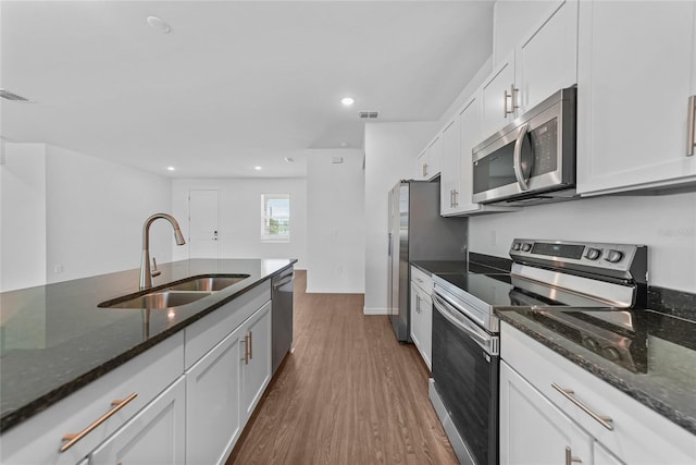 7345 Ellis Ln, Port Charlotte, FL 33981 - kitchen featuring appliances with stainless steel finishes, dark wood-style floors, white cabinets, dark stone countertops, and recessed lighting