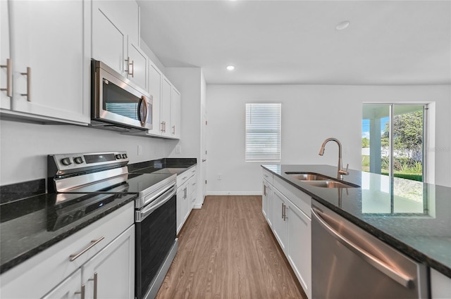 7345 Ellis Ln, Port Charlotte, FL 33981 - kitchen with stainless steel appliances, wood finished floors, dark stone countertops, white cabinets, and recessed lighting