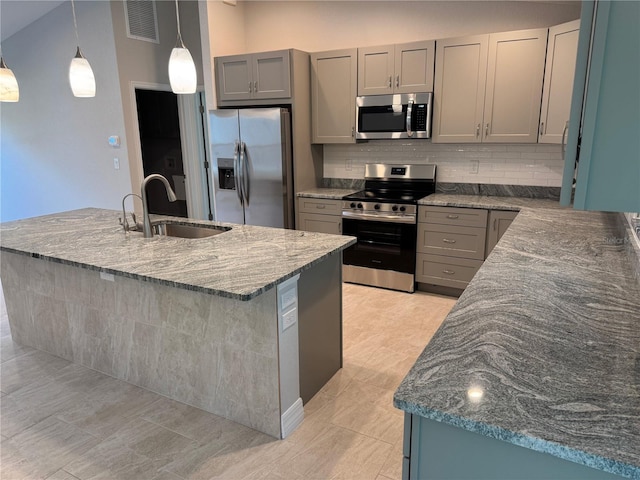 2451 Waller Rd, North Port, FL 34288 - kitchen featuring stainless steel appliances, gray cabinets, dark stone counters, and decorative backsplash
