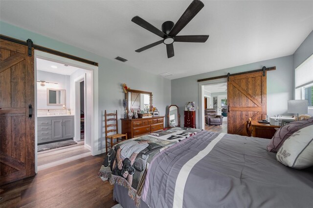 405 Ridgecrest Dr, Punta Gorda, FL 33982 - bedroom featuring a barn door, dark wood-style floors, ensuite bath, ceiling fan, and a sink