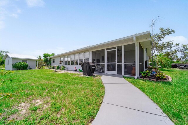405 Ridgecrest Dr, Punta Gorda, FL 33982 - rear view of property featuring a sunroom and a lawn