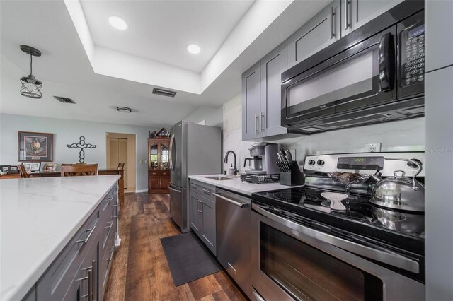 405 Ridgecrest Dr, Punta Gorda, FL 33982 - kitchen featuring appliances with stainless steel finishes, a tray ceiling, a sink, gray cabinets, and recessed lighting