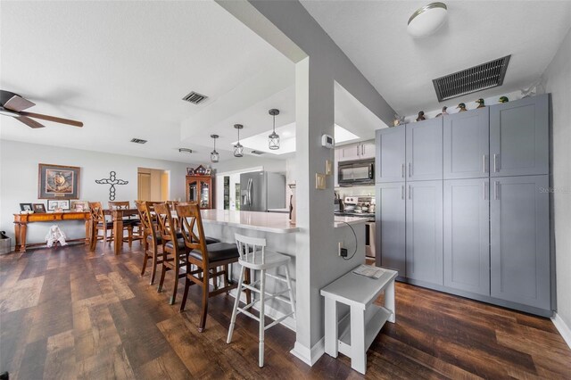 405 Ridgecrest Dr, Punta Gorda, FL 33982 - kitchen featuring stainless steel appliances, a breakfast bar, dark wood-type flooring, a peninsula, and a ceiling fan