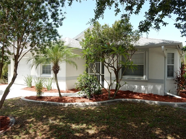 500 Winwood Ct, Port Charlotte, FL 33954 - view of side of home featuring stucco siding, a shingled roof, a garage, and concrete driveway