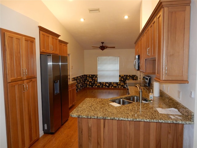 500 Winwood Ct, Port Charlotte, FL 33954 - kitchen featuring appliances with stainless steel finishes, a ceiling fan, brown cabinets, light wood-type flooring, and vaulted ceiling