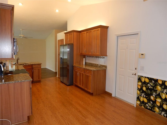 500 Winwood Ct, Port Charlotte, FL 33954 - kitchen featuring stainless steel appliances, brown cabinetry, ceiling fan, vaulted ceiling, and light wood-style flooring