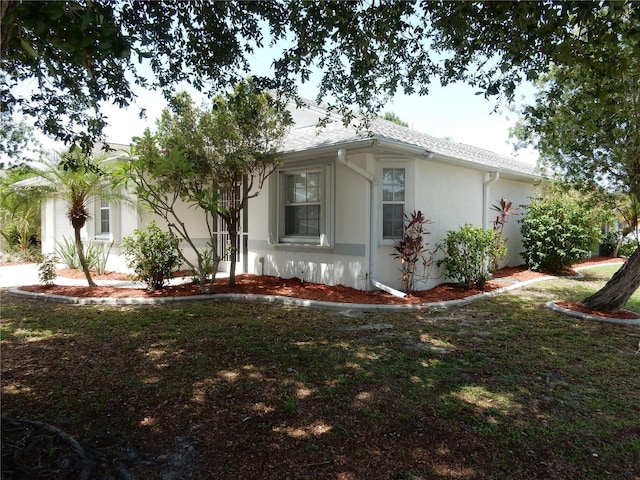 500 Winwood Ct, Port Charlotte, FL 33954 - view of side of home featuring stucco siding and a yard