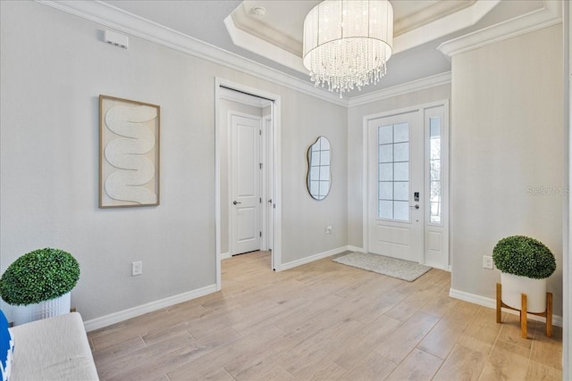 15039 Black Cherry Way, Punta Gorda, FL 33955 - entryway featuring ornamental molding, a chandelier, light wood-type flooring, and a tray ceiling