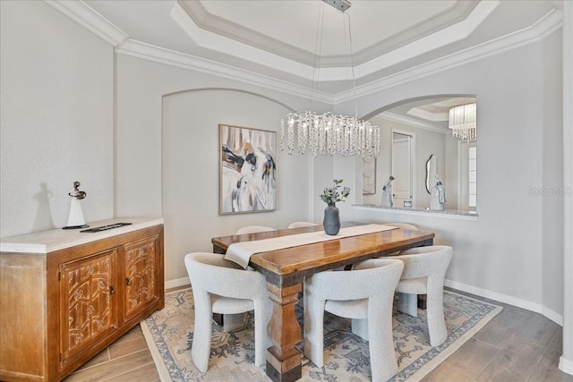 15039 Black Cherry Way, Punta Gorda, FL 33955 - dining area with a chandelier, a raised ceiling, ornamental molding, light wood-style flooring, and arched walkways