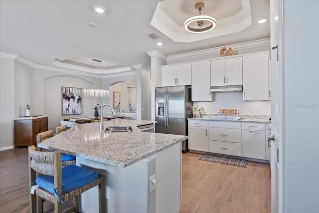 15039 Black Cherry Way, Punta Gorda, FL 33955 - kitchen featuring a tray ceiling, ornamental molding, arched walkways, stainless steel fridge, and under cabinet range hood