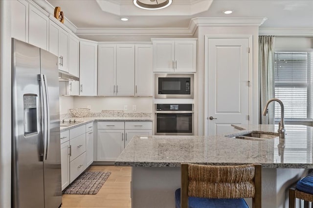 15039 Black Cherry Way, Punta Gorda, FL 33955 - kitchen with appliances with stainless steel finishes, ornamental molding, under cabinet range hood, light wood finished floors, and a breakfast bar