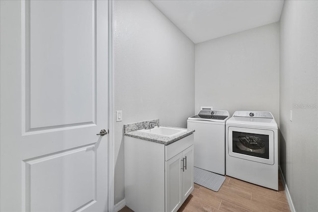 15039 Black Cherry Way, Punta Gorda, FL 33955 - washroom featuring light wood-type flooring, washing machine and clothes dryer, and cabinet space