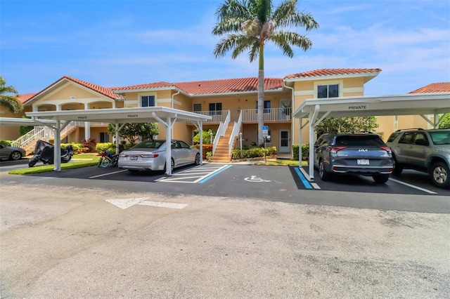 196 Furse Lakes Cir Unit A6, Naples, FL 34104 - view of building exterior featuring stairs and covered and uncovered parking