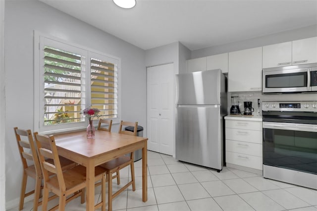 196 Furse Lakes Cir Unit A6, Naples, FL 34104 - kitchen featuring stainless steel appliances, white cabinetry, decorative backsplash, light countertops, and light tile patterned floors