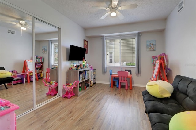 196 Furse Lakes Cir Unit A6, Naples, FL 34104 - rec room with a ceiling fan, wood finished floors, a textured ceiling, and baseboards