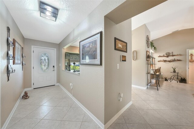 37 Pepe Ct, Punta Gorda, FL 33983 - entrance foyer featuring light tile patterned floors, a textured ceiling, and lofted ceiling