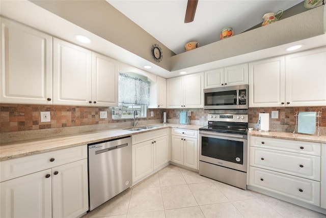 37 Pepe Ct, Punta Gorda, FL 33983 - kitchen with stainless steel appliances, tasteful backsplash, vaulted ceiling, white cabinetry, and light tile patterned flooring