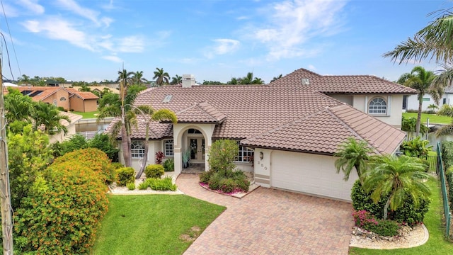 250 Freeport Ct, Punta Gorda, FL 33950 - mediterranean / spanish-style house with stucco siding, a tile roof, a garage, decorative driveway, and a front yard