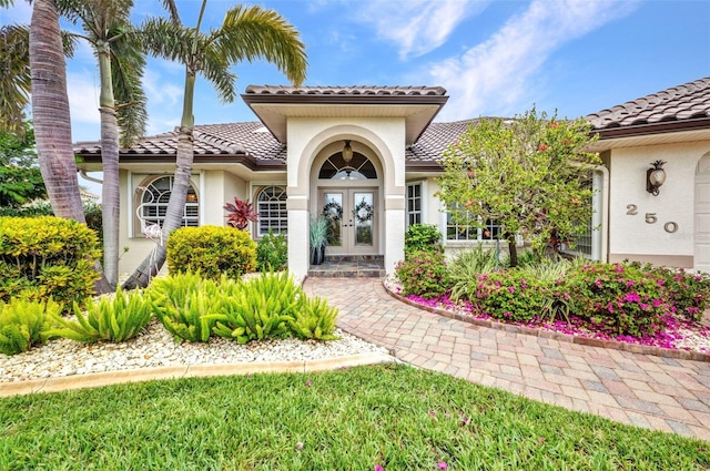250 Freeport Ct, Punta Gorda, FL 33950 - entrance to property with french doors, stucco siding, and a tiled roof