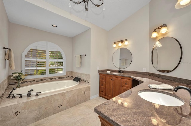 250 Freeport Ct, Punta Gorda, FL 33950 - full bath featuring two vanities, a garden tub, tile patterned flooring, vaulted ceiling, and a chandelier