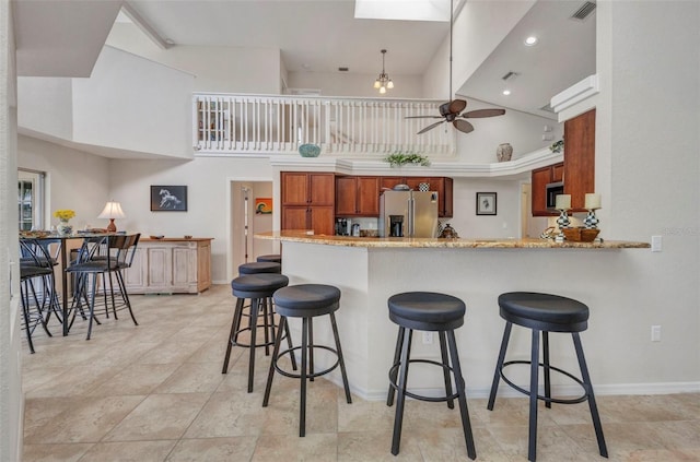 250 Freeport Ct, Punta Gorda, FL 33950 - kitchen with stainless steel fridge with ice dispenser, high vaulted ceiling, a ceiling fan, a kitchen breakfast bar, and a peninsula