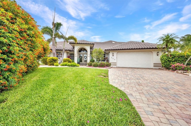 250 Freeport Ct, Punta Gorda, FL 33950 - mediterranean / spanish home featuring stucco siding, a tile roof, a garage, decorative driveway, and a front lawn