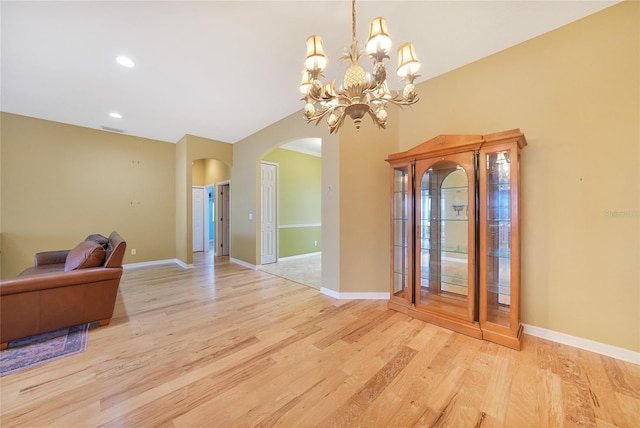 1527 Aqui Esta Dr Unit 3, Punta Gorda, FL 33950 - living room featuring arched walkways, light wood-style floors, a chandelier, lofted ceiling, and recessed lighting