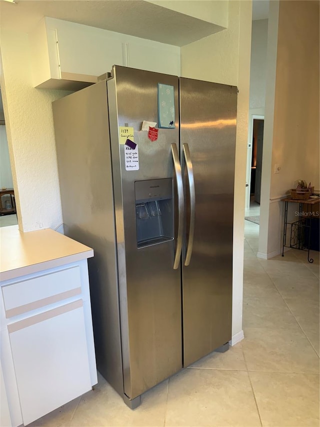26312 Deep Creek Blvd, Punta Gorda, FL 33983 - kitchen featuring stainless steel fridge with ice dispenser, light tile patterned floors, white cabinetry, and light countertops
