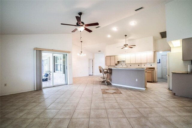 23101 Hillsdale Ave, Port Charlotte, FL 33954 - kitchen featuring ceiling fan, high vaulted ceiling, a kitchen breakfast bar, light tile patterned floors, and freestanding refrigerator