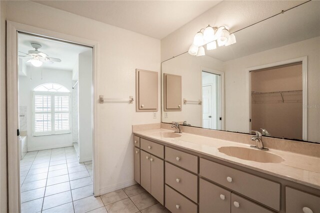 23101 Hillsdale Ave, Port Charlotte, FL 33954 - bathroom with double vanity, tile patterned flooring, a ceiling fan, a walk in closet, and baseboards