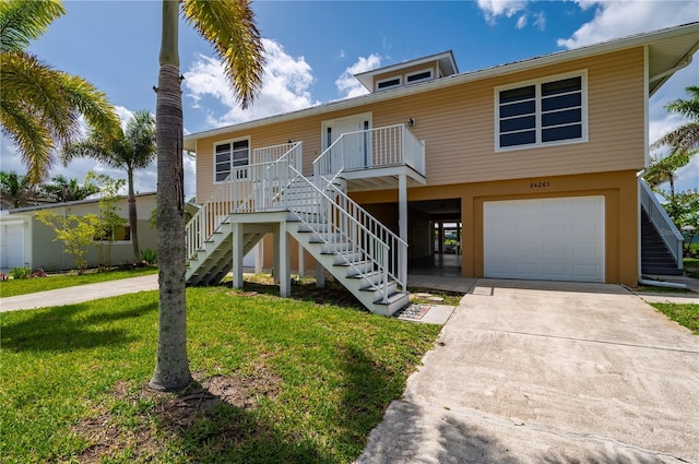 24261 Captain Kidd Blvd, Punta Gorda, FL 33955 - coastal inspired home featuring stairs, an attached garage, a front yard, and driveway