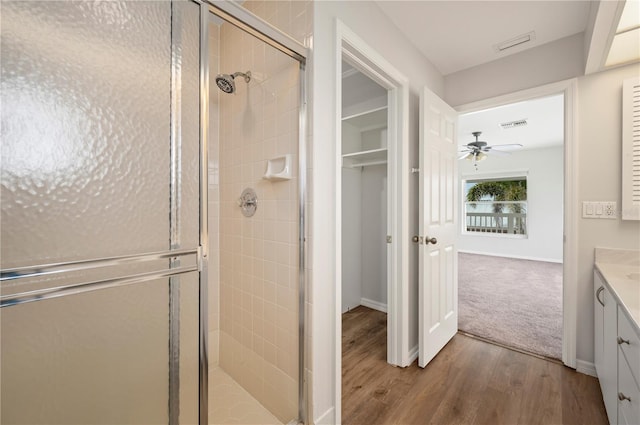 24261 Captain Kidd Blvd, Punta Gorda, FL 33955 - bathroom with a shower stall, a ceiling fan, vanity, wood finished floors, and a closet