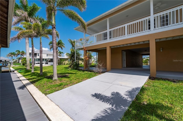 24261 Captain Kidd Blvd, Punta Gorda, FL 33955 - view of side of home with a yard, concrete driveway, and stucco siding