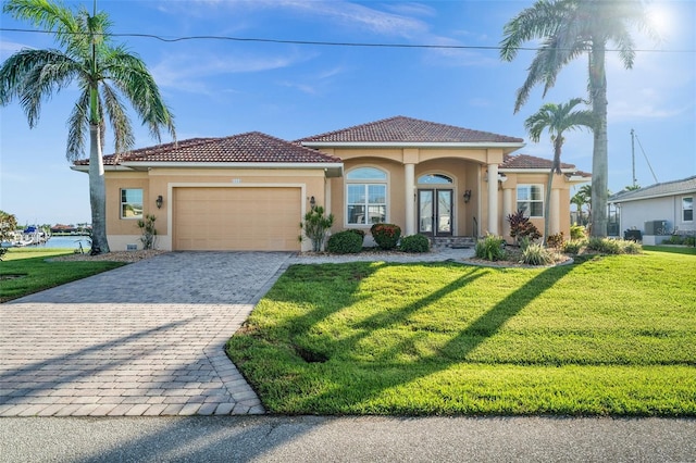 3322 Sandpiper Dr, Punta Gorda, FL 33950 - mediterranean / spanish house featuring stucco siding, an attached garage, a front lawn, and decorative driveway