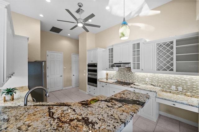 3322 Sandpiper Dr, Punta Gorda, FL 33950 - kitchen with black electric stovetop, stainless steel double oven, a towering ceiling, light tile patterned floors, and backsplash