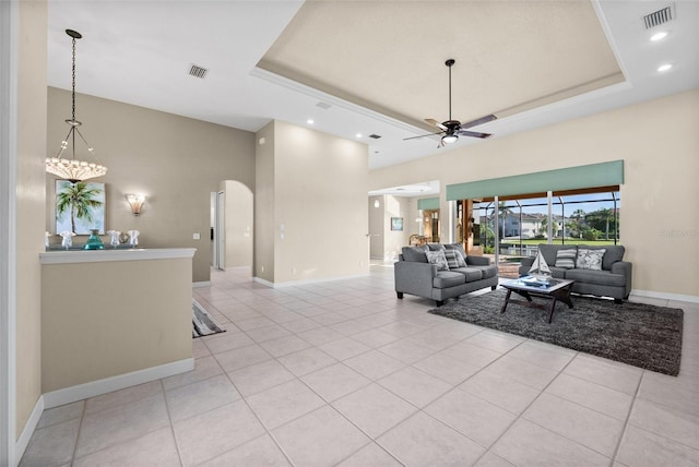 3322 Sandpiper Dr, Punta Gorda, FL 33950 - living area featuring a towering ceiling, ceiling fan, a tray ceiling, light tile patterned flooring, and arched walkways