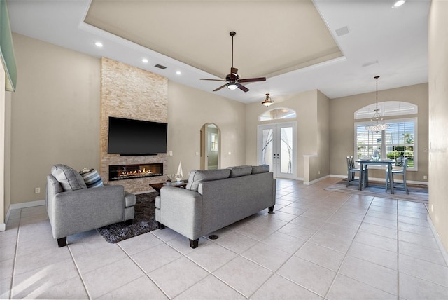 3322 Sandpiper Dr, Punta Gorda, FL 33950 - living area with a raised ceiling, light tile patterned floors, french doors, ceiling fan, and a stone fireplace