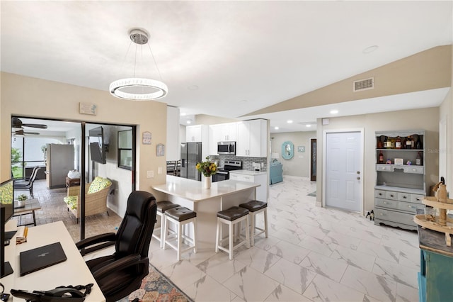 1141 Paraclete Rd, Punta Gorda, FL 33983 - kitchen featuring appliances with stainless steel finishes, a kitchen bar, white cabinets, backsplash, and light countertops