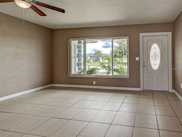 6483 Fabian Rd, North Port, FL 34287 - foyer entrance with plenty of natural light, a ceiling fan, a textured ceiling, and light tile patterned flooring