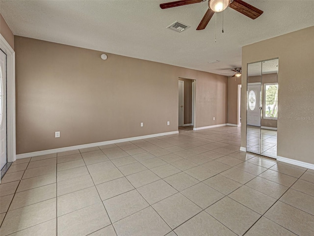 6483 Fabian Rd, North Port, FL 34287 - empty room featuring a ceiling fan, a textured ceiling, and light tile patterned floors