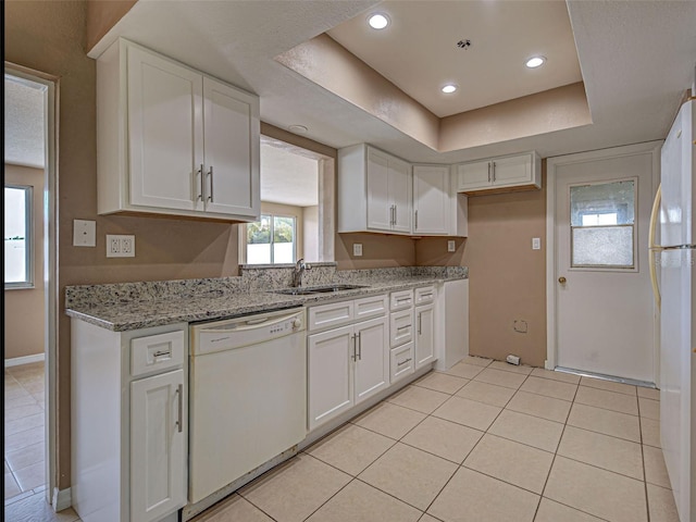 6483 Fabian Rd, North Port, FL 34287 - kitchen with white appliances, white cabinets, light tile patterned flooring, light stone countertops, and recessed lighting