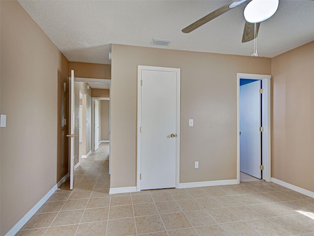 6483 Fabian Rd, North Port, FL 34287 - unfurnished bedroom with light tile patterned floors, a textured ceiling, and a ceiling fan